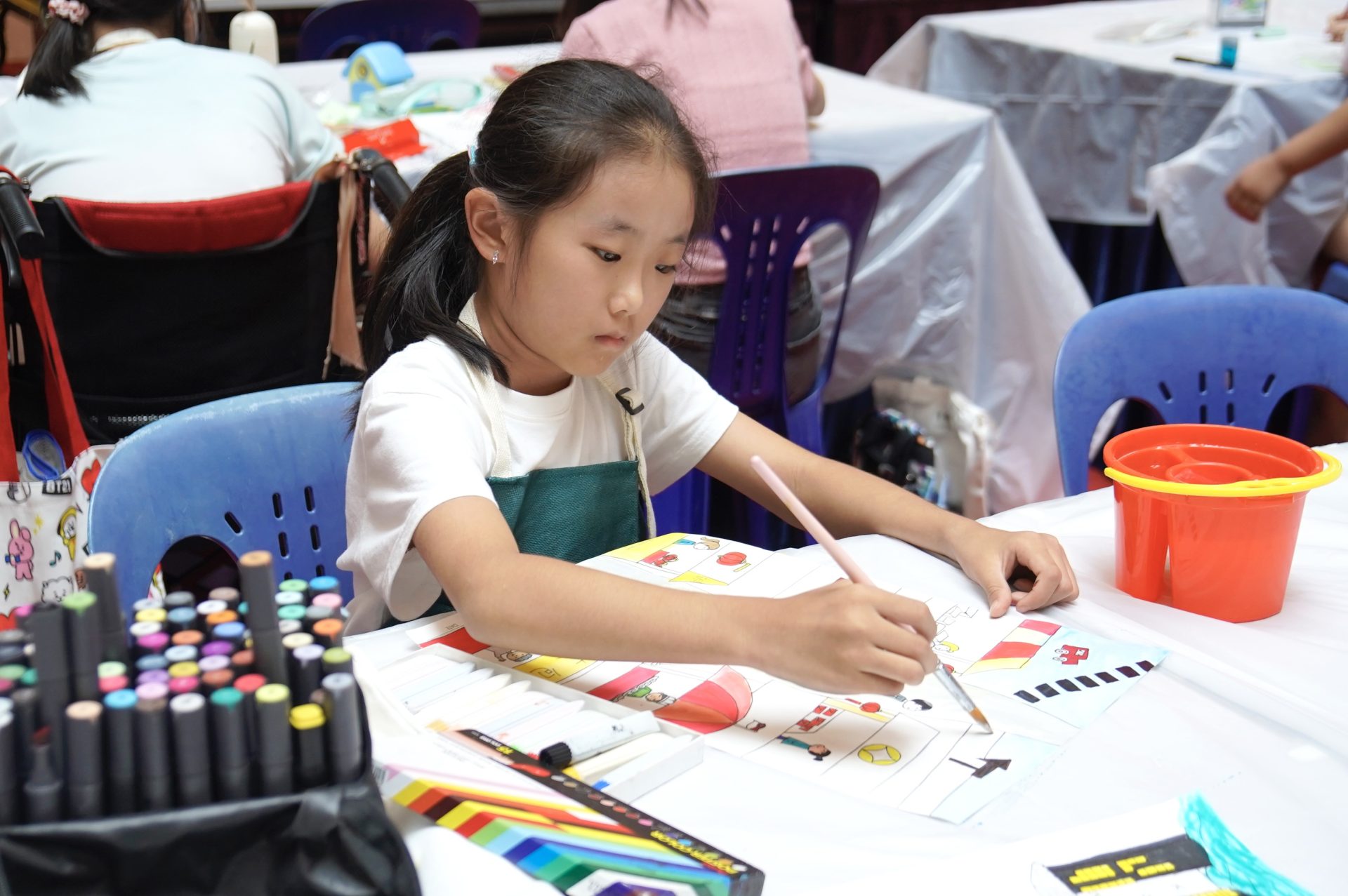 Girl deep in concentration painting at the studio