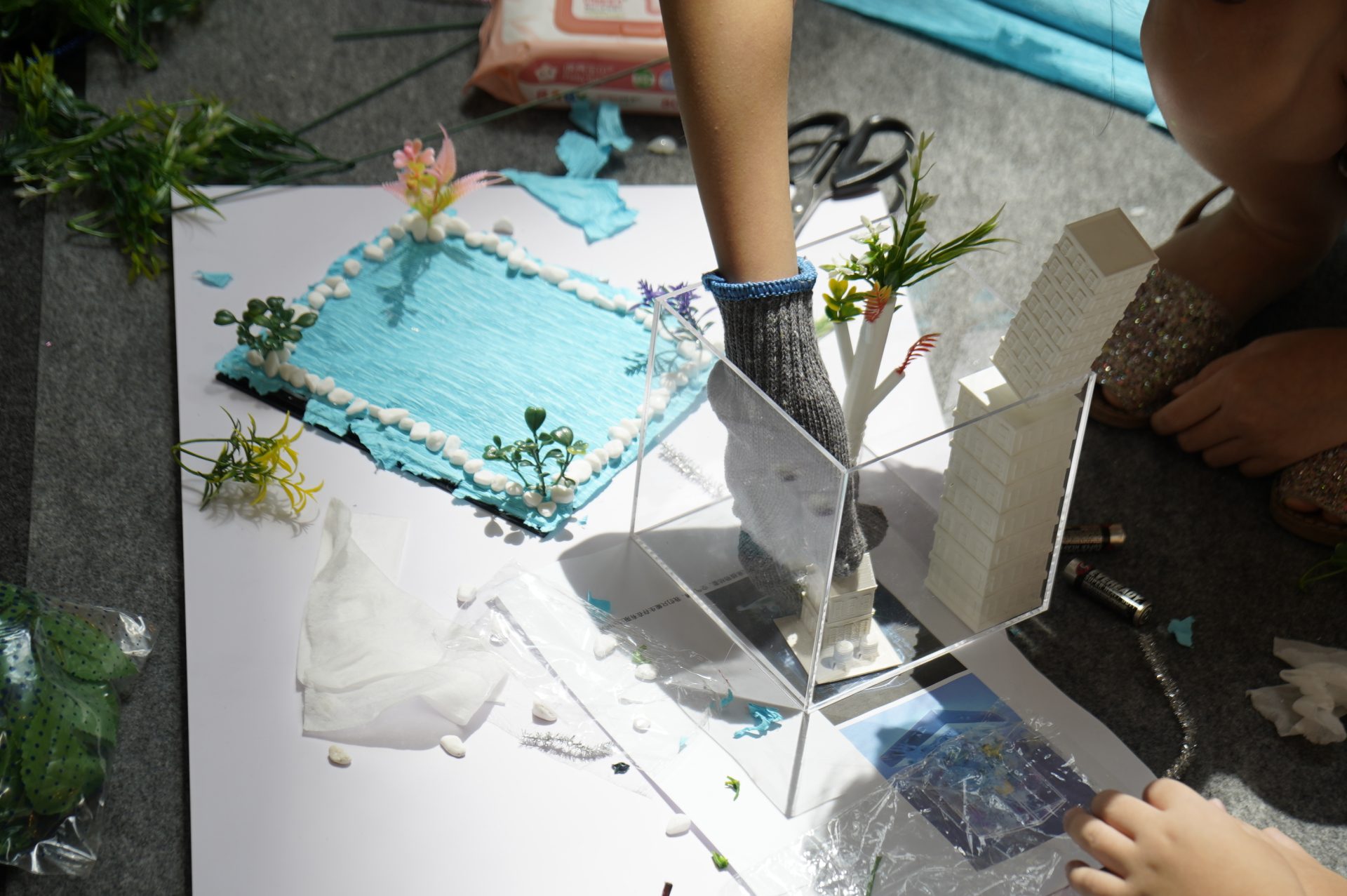 A child's hands carefully placing an acrylic module onto an artwork